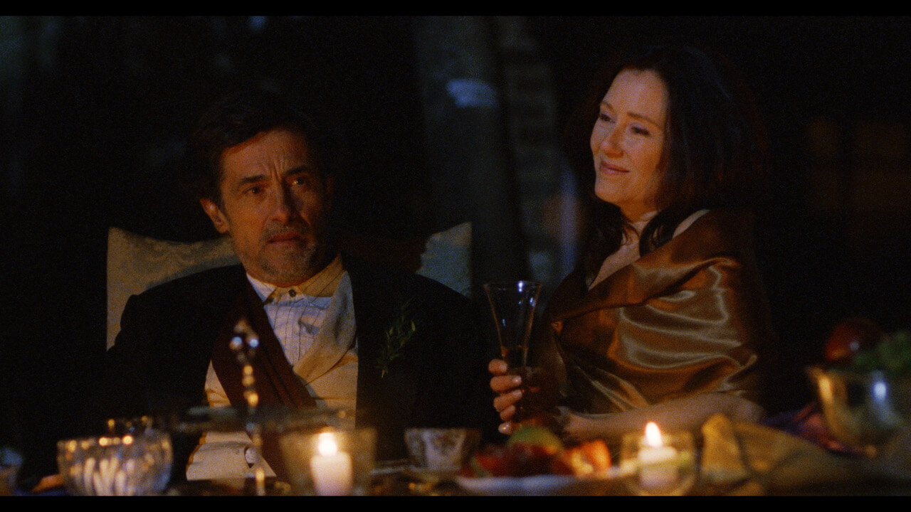 Mary and Roger at evening garden party, seated at the dinner table